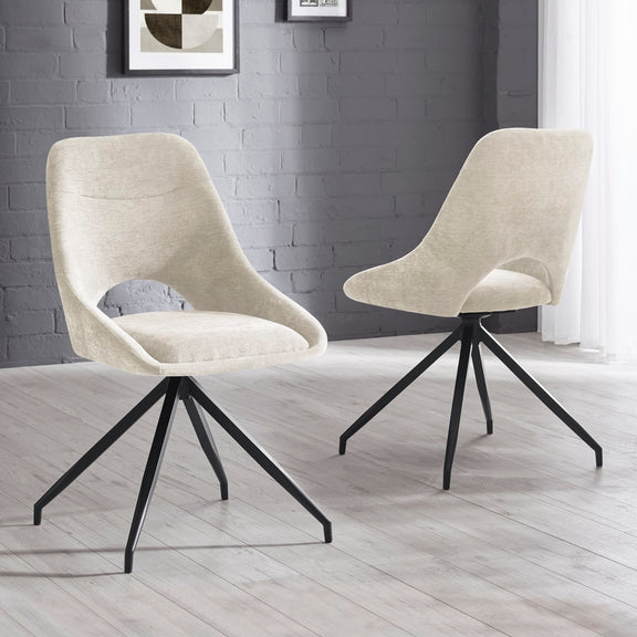 Two beige chairs with black metal legs on a light wooden floor against a gray brick wall.