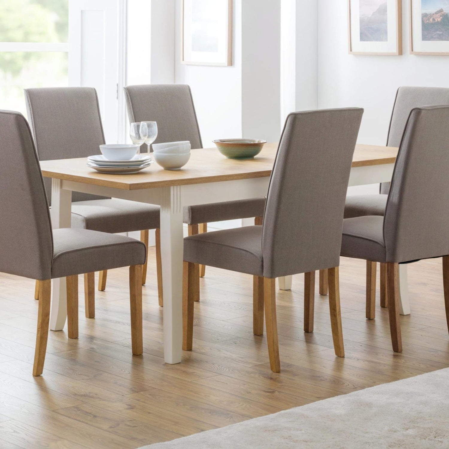 Dining room with wooden table and gray chairs in a well-lit room.