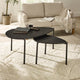 Black nesting tables in a living room setting with a beige sofa and decor.