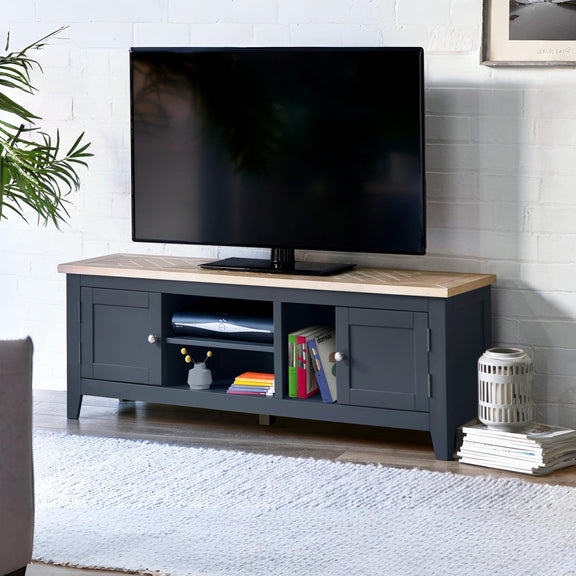 Black TV stand with a wooden top displaying a television, books, and decorative items in a living room setting.
