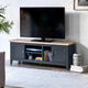 Black TV stand with a wooden top displaying a television, books, and decorative items in a living room setting.