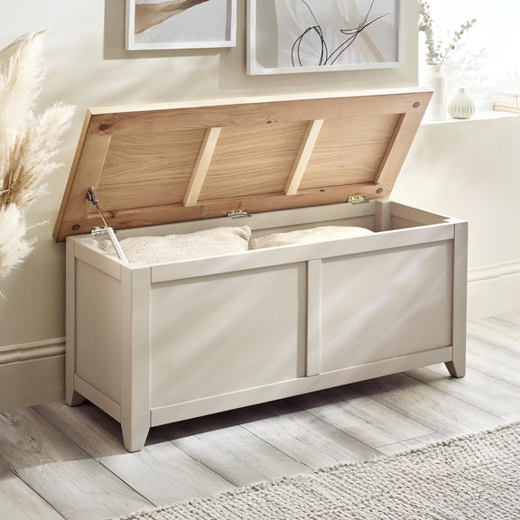 White storage bench with open lid in a room with light-colored walls and flooring.