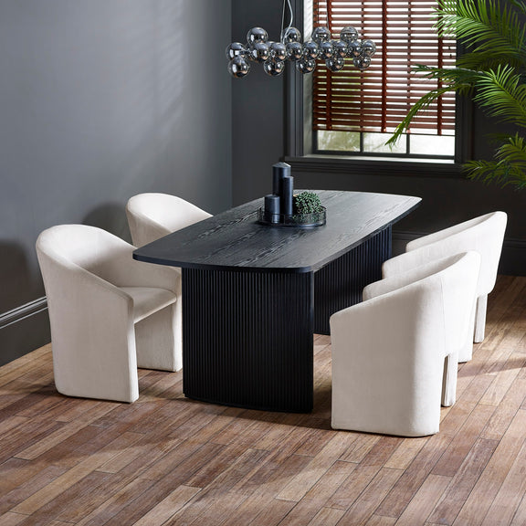 Dining room with a black rectangular table and white chairs on a wooden floor.