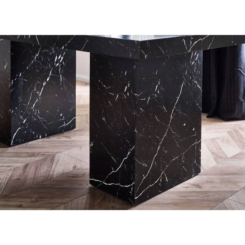 Black marble dining table with a modern design on a wooden floor.