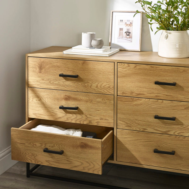 Wooden dresser with open drawer in a room setting