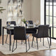 Dining room with a black table and chairs on a white rug, with a large window in the background.