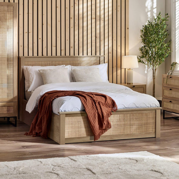 Wooden bed with white bedding and a red blanket in a bedroom setting.