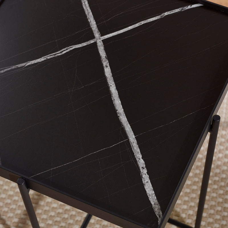 Black marble table with white veins on a textured surface