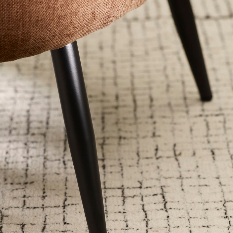 Close-up of a chair leg on a textured carpet