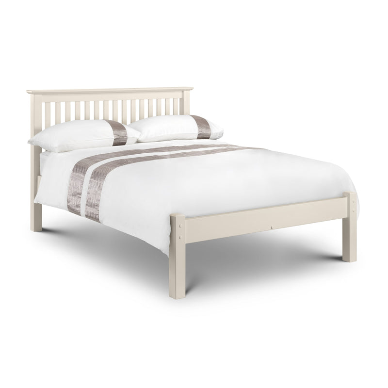 White bed frame with white bedding and gray striped pillows on a white background