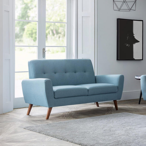 Light blue sofa in a modern living room with large windows and minimal decor.