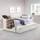 White bed with trundle in a room with framed pictures on the wall.