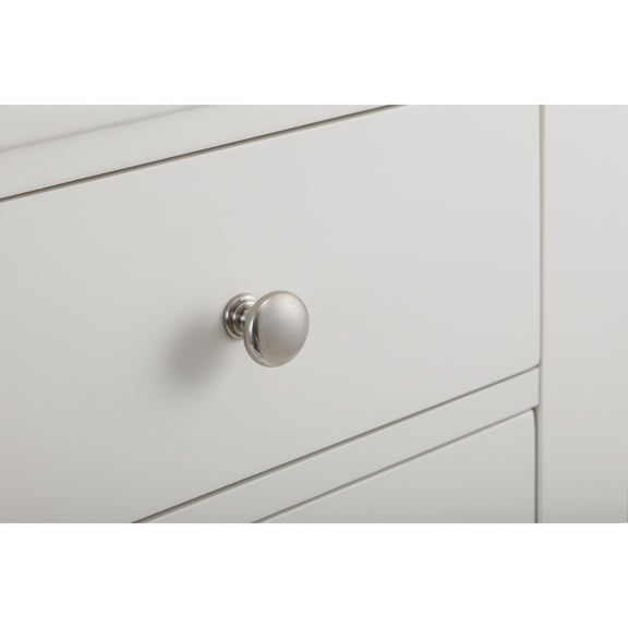 Close-up of a light gray cabinet with a silver knob on a white background