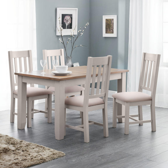 Dining room with a wooden table and four matching chairs in a well-lit room.