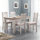 Dining room with a wooden table and four matching chairs in a well-lit room.