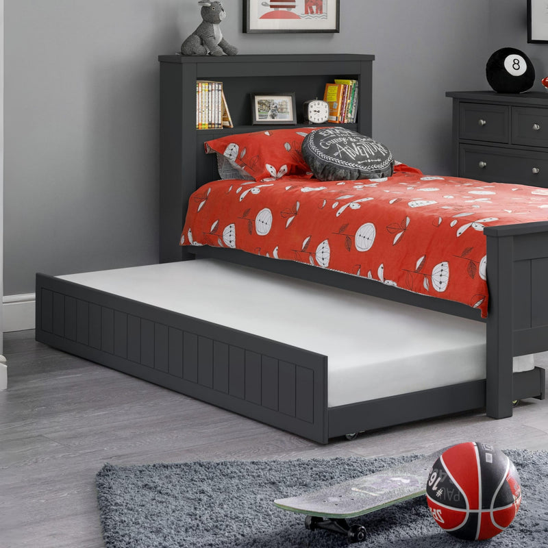 Children's bedroom with a gray bed frame, red bedding, and sports balls on the floor.