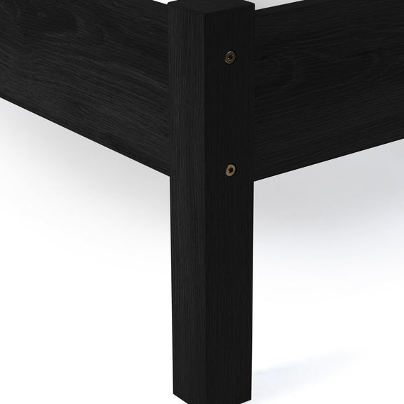 Close-up of a black wooden bed frame corner on a white background