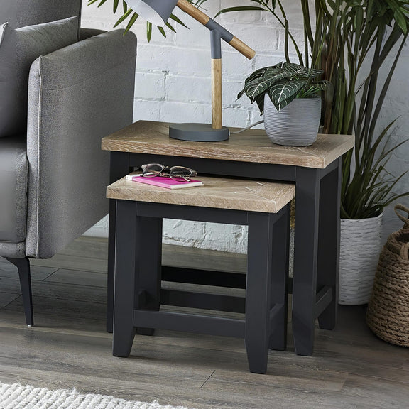 Side table with wooden top and black base in a living room setting