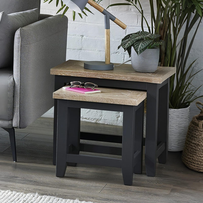 Side table with wooden top and black base in a living room setting