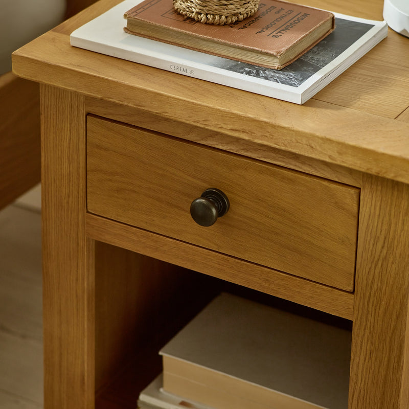 Wooden nightstand with a drawer and books on top