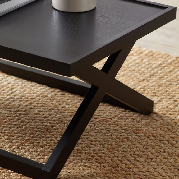 Black coffee table with a textured surface on a beige carpet