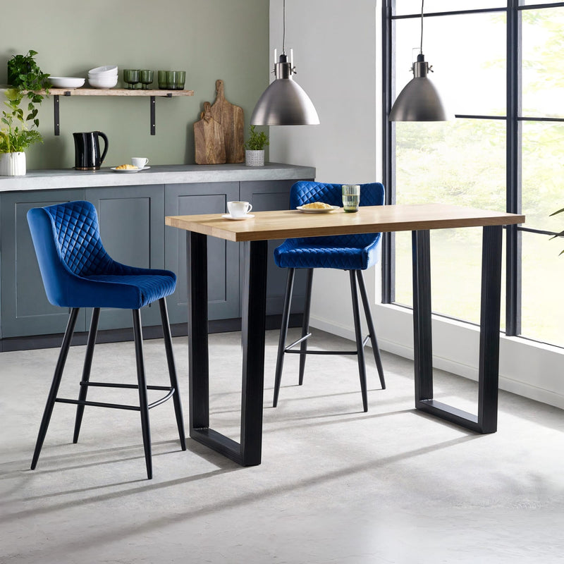 Modern kitchen with a wooden dining table and blue bar stools.
