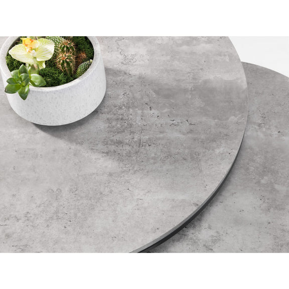 Round concrete table with a small potted plant on a white background