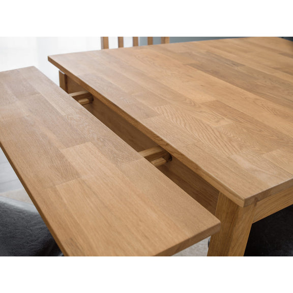 Wooden dining table with bench on a white background