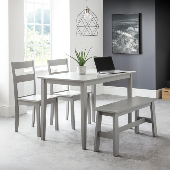 Gray dining set with table, chairs, and bench in a room with a window and artwork on the wall.