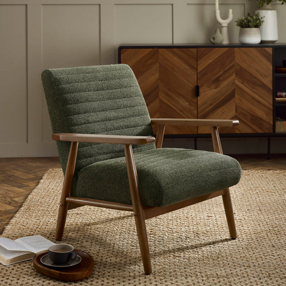 Green armchair in a room with wooden furniture and decor