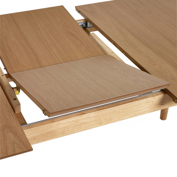 Wooden dining table with extendable leaves on a white background