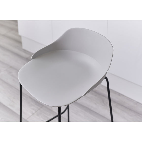 Modern white chair with black legs on a light wooden floor.