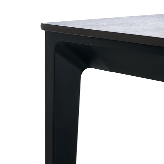 Close-up of a black metal table leg with a white surface.