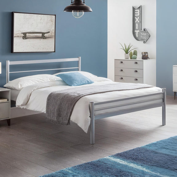 Bedroom with a metal bed frame, white bedding, and blue accents.
