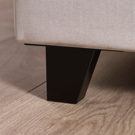 Close-up of a sofa leg on a wooden floor