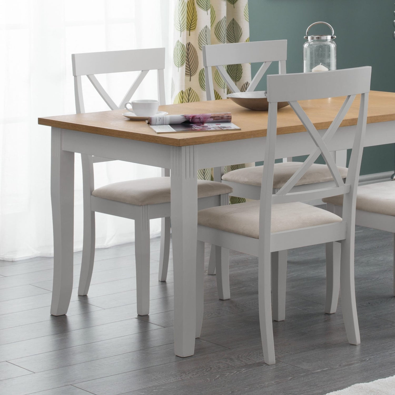 Dining table with four chairs in a room with curtains and a light fixture.