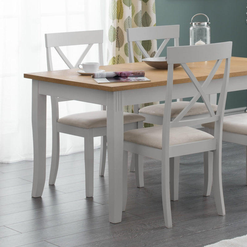 Dining table with four chairs in a room with curtains and a light fixture.