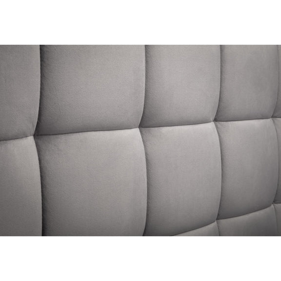 Gray tufted headboard with a quilted pattern on a white background