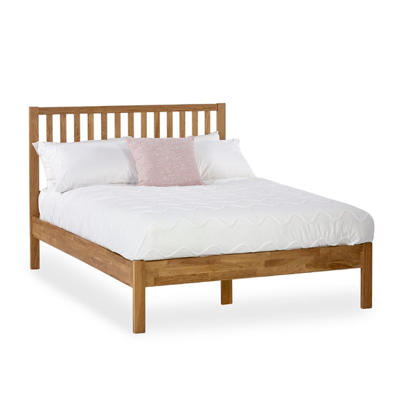 Wooden bed with white bedding and pillows on a white background