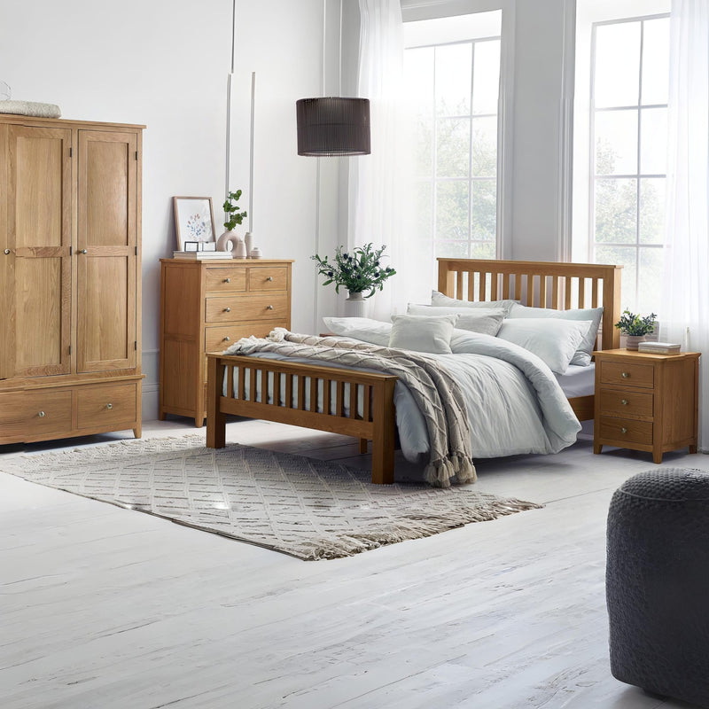 Wooden bedroom furniture set with bed, wardrobe, and nightstands in a bright room.
