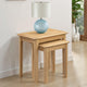 Two wooden side tables with a lamp on a light wood floor.