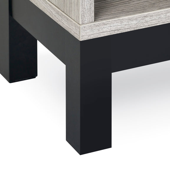 Close-up of a corner where a black and gray wooden table meets a white floor.