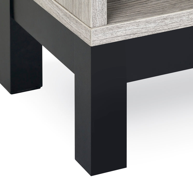 Close-up of a corner where a black and gray wooden table meets a white floor.