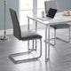 Modern dining chairs with gray seats and metal frames in a room with a table and laptop.