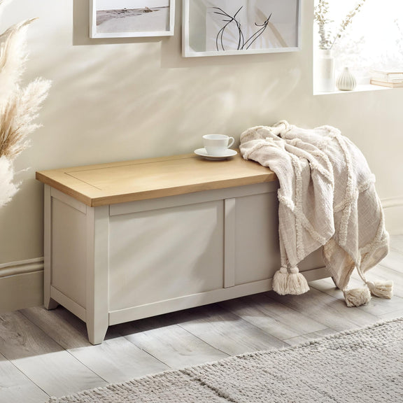 White storage bench with wooden top in a room setting with decor elements.