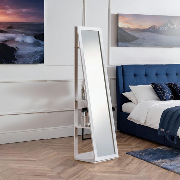 Standing mirror in a bedroom with a blue bed and artwork on the wall.
