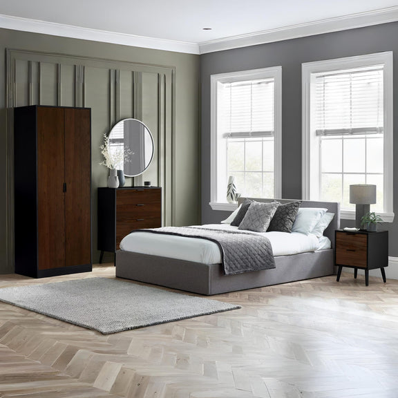 Modern bedroom with gray bed, wooden wardrobes, and large windows.