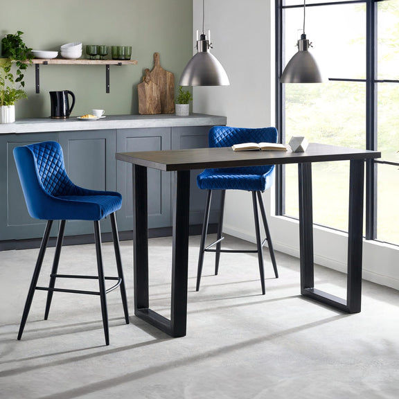 Modern kitchen with a black dining table and blue bar stools.