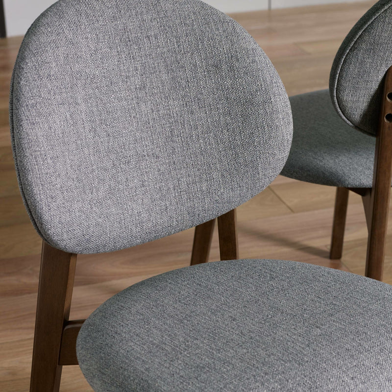 Gray upholstered chairs with wooden legs on a wooden floor.