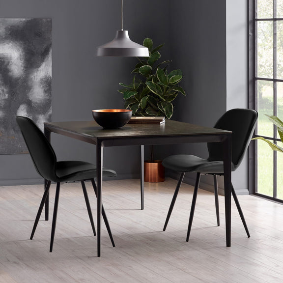 Dining room with a dark wooden table and black chairs against a gray wall.